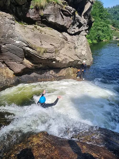 personne qui réalise glisse dans un toboggan naturel