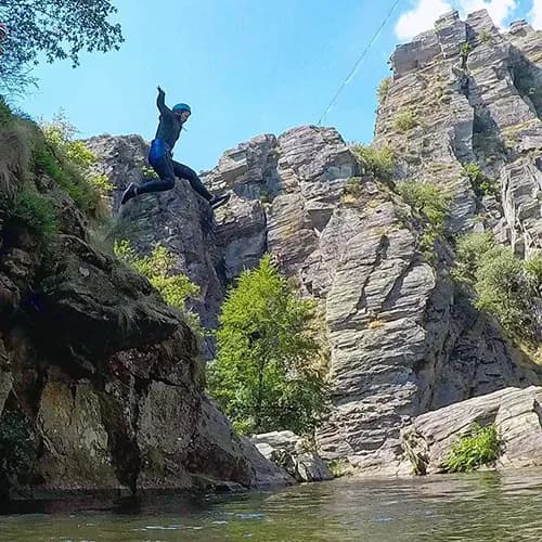 personne qui réalise un saut dans une cascade
