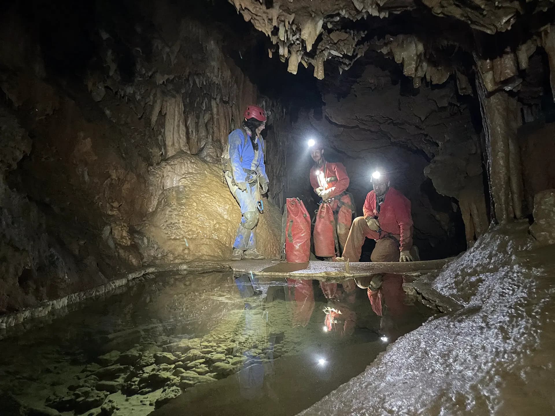 groupe d'adultes devant une rivière souterraine