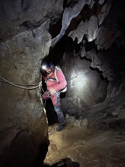 Spéléologie , adulte en progression dans une grotte